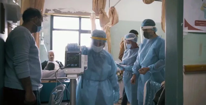 Medizinisches Personal mit Covid-19-Ausrüstung in einem Krankenhauszimmer 