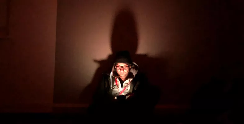 Oliver Barth schut in einem dunklen Luftschutzkeller auf sein Handy