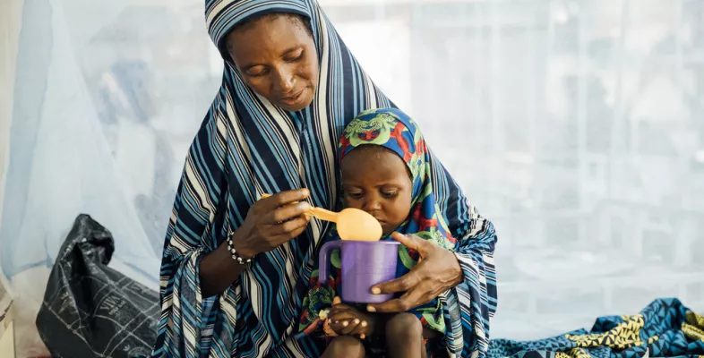 Eine Mutter füttert ihre 2-jährige Tochter auf der Mangelernährungsstation in einem Krankenhaus in Niger