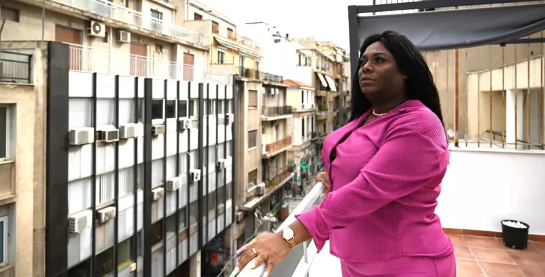 Yuli steht auf einem Balkon.