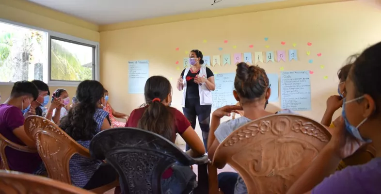 Eine Mitarbeiterin im Gespräch mit Jugendlichen in Honduras.