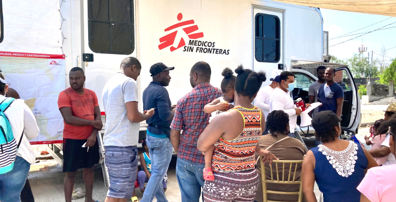 Migranten warten vor einer mobilen Klinik