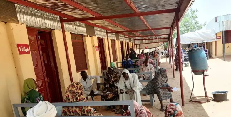 Menschen warten vor einer Klinik in Nord-Darfur auf medizinische Versorgung.