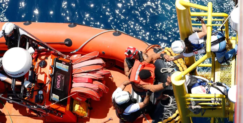 Eine gerettete Person klettert an Bord der Geo Barents