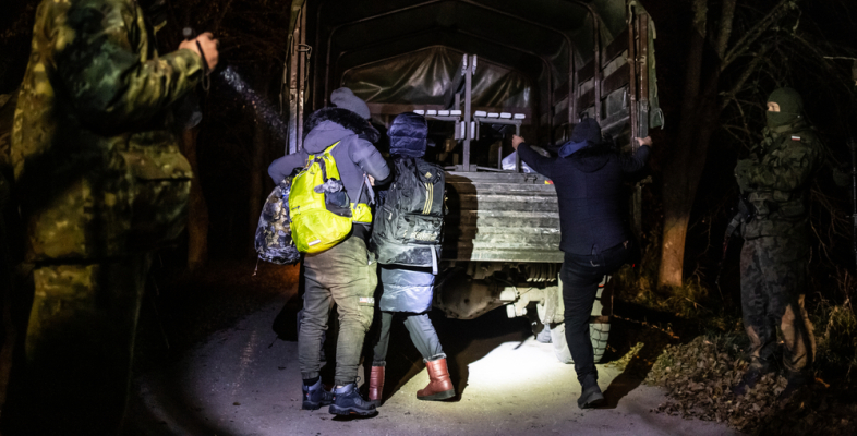 Militärfahrzeug und Geflüchtete an der Grenze zu Polen