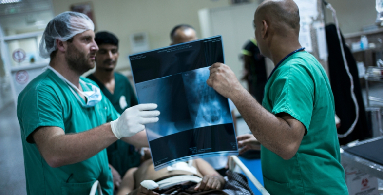 Chirurgen besprechen Röntgenbild mit Patient - humanitäre Arbeit