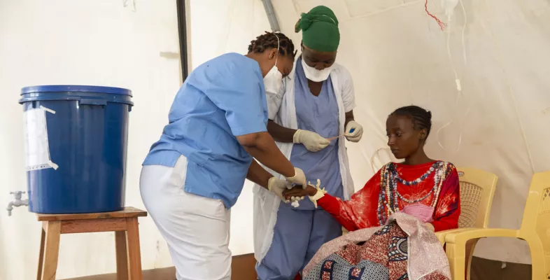 Pflegerinnen versorgen Patientin in Cholera-Behandlungszelt