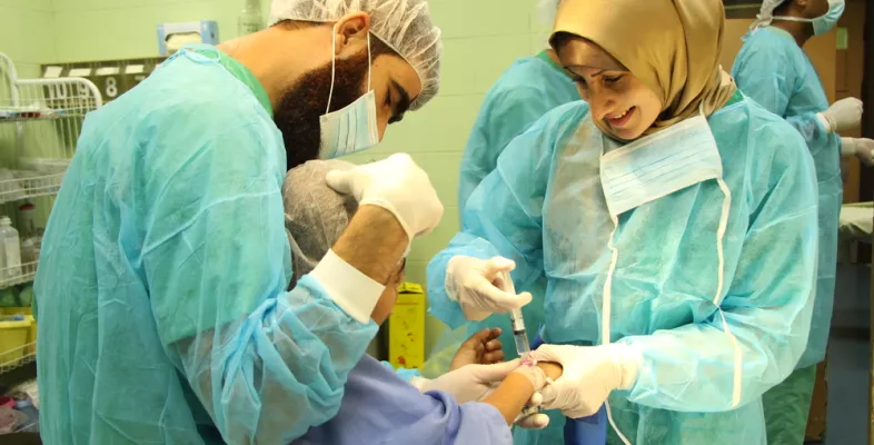 Lächelnde Anästhesistin spritzt Kind ein Medikament