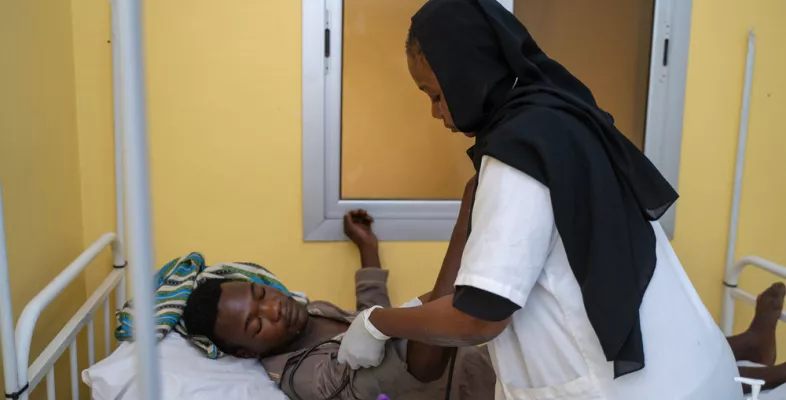 Krankenschwester mit Stethoskop an Patientenbett