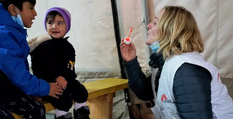 Mitarbeiterin spielt mit geflüchteten Kindern mit Seifenblasen auf Lesbos.