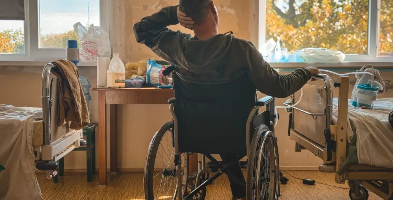 Patient sitzt im Rollstuhl in einem Krankenhauszimmer