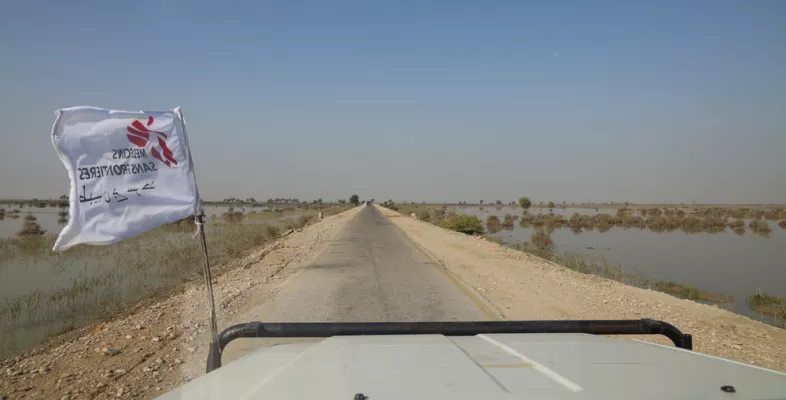 Fahrzeug mit Logo-Fahne von Ärzte ohne Grenzen unterwegs