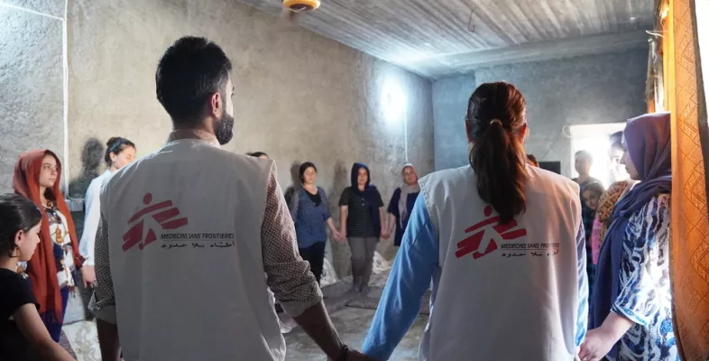 Irak: Mitarbeitende und Patient*innen stehen in Kreis und halten Hände