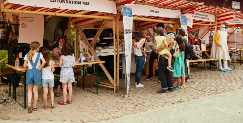 Besucher*innen informieren sich an Info-Ständen.