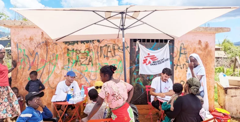 Mobiles Team und Patient*innen vor Hütte