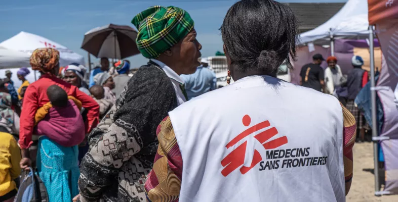 Mitarbeitende steht draußen vor Patient*innen