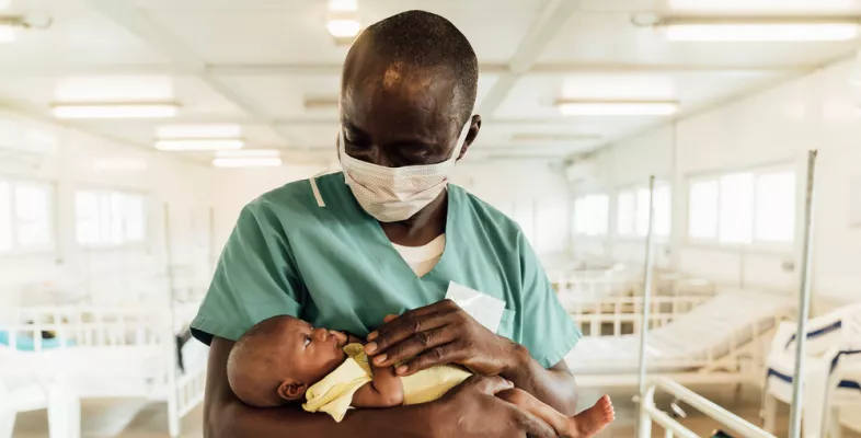 In der Kinderklinik in Kenema behandeln wir seit März 2019 Kinder unter 5 Jahren Charles Jormoh mit Kind auf dem Arm