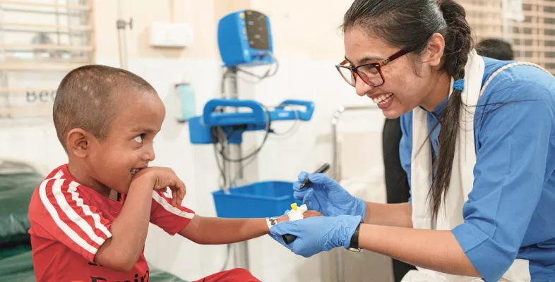 Mitarbeitende behandelt ein Kind.