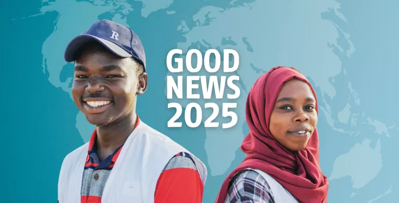 Zwei Personen stehen Rücken an Rücken und lächeln in die Kamera. Dahinter der Schriftzug "Good News".