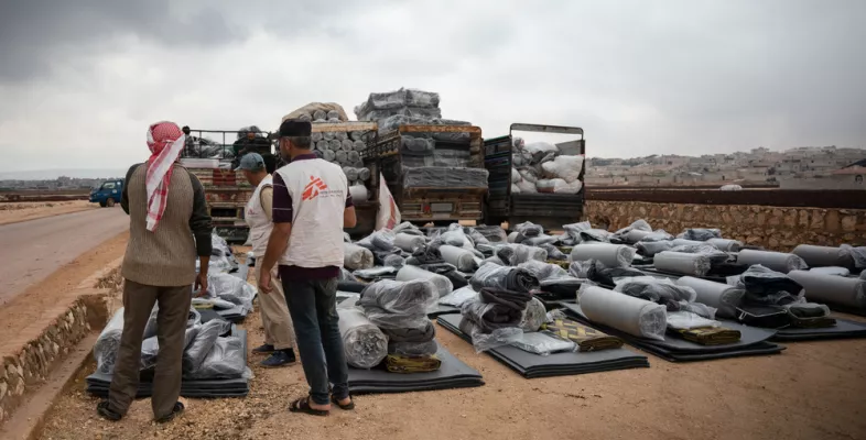 Mitarbeitende von uns sortieren Hilfsgüter und Matratzen.