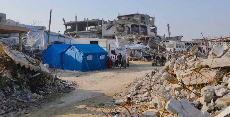 In einem Trümmerfeld ist ein Zelt errichtet worden.
