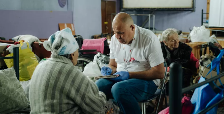 Ein Mitarbeiter von Ärzte ohne Grenzen spricht mit einer Patientin.