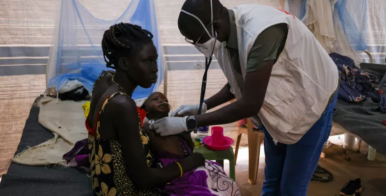 Eine Mutter hält bei der Untersuchung ihr an Tuberkulose erkranktes Kind im Arm.