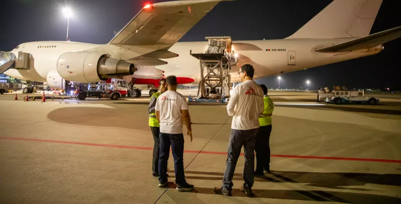 Zwei Menschen vor einem Flugzeug mit Hilfsgütern