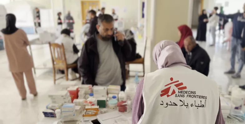 Eine Mitarbeiterin gibt Medikamente an Patient*innen aus.