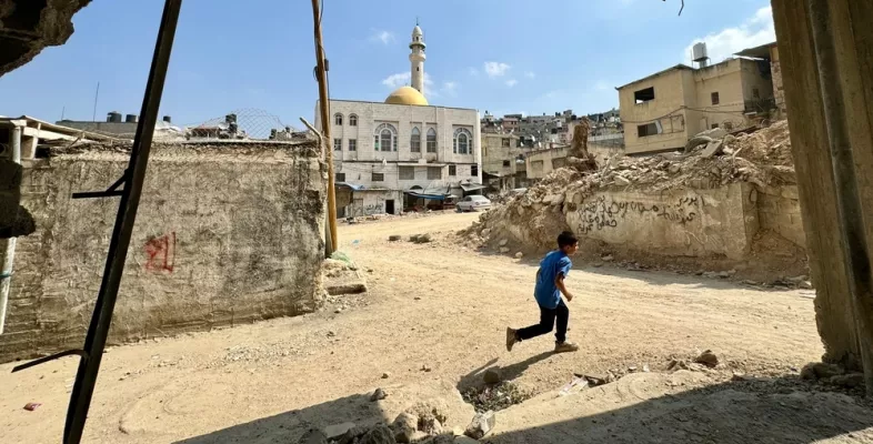 Ein Junge rennt durch eine zerstörte Stadt.