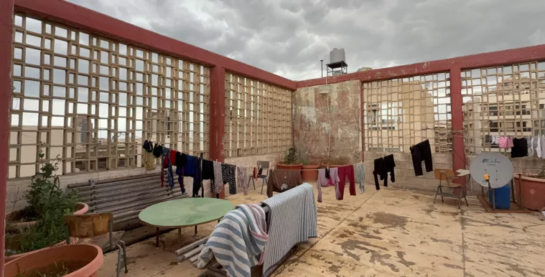 Wäsche hängt an Wäscheleinen auf einem Flachdach.