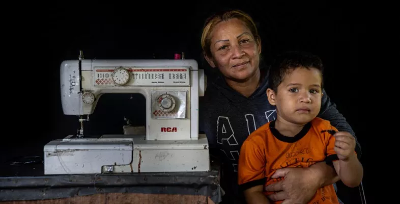Eine Venezolanerin mit ihrem Sohn und einer Nähmaschine