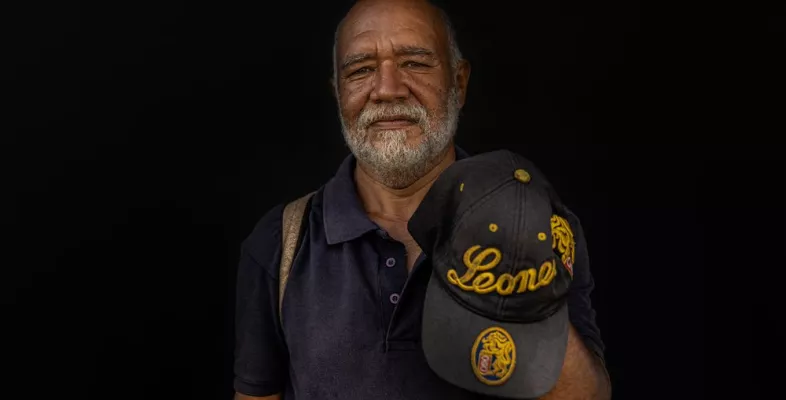 Ein Venezolaner mit einer Baseballmütze in der Hand