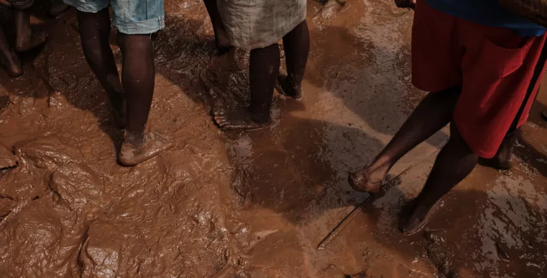Menschen stehen mit ihren Füßem im Schlamm nach den Wirbelstürmen im Osten Madagaskars