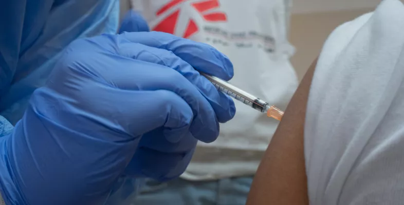 Nahaufnahme von einer Hand, die eine Covid-19 Impfung spritzt