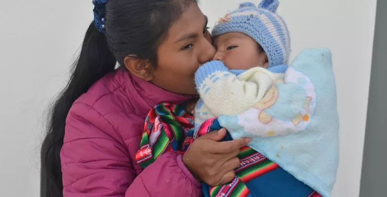 Die Gesundheitsförderin Maribel Camargo Paco küsst ihren 6 Monate alten Sohn