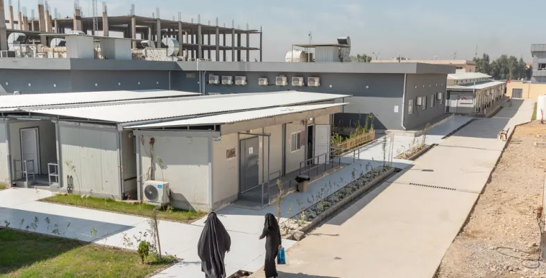 Der Krankenhauskomplex aus der Vogelperspektive mit zwei Frauen die auf den Eingang zu laufen