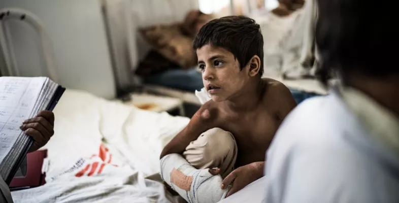 Ein Kind sitzt auf dem Bett einer orthopädischen Station unseres Krankenhauses in Boost.