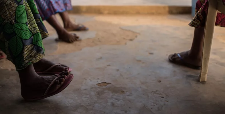 Beine und Füße von Menschen die im Kreis sitzen