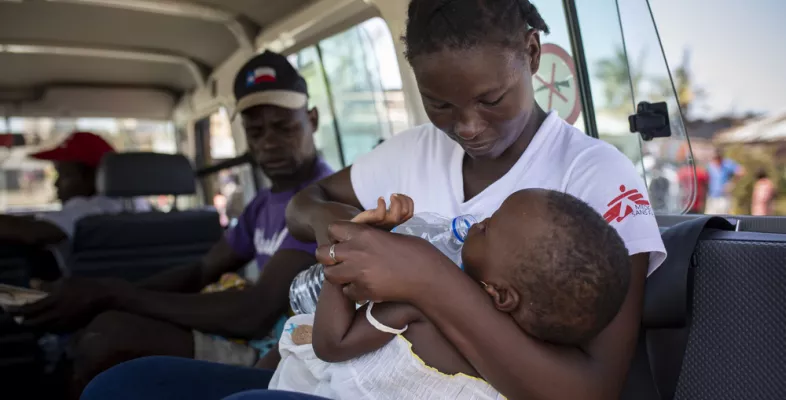 Mitarbeiterin hält krankes Kind im Arm