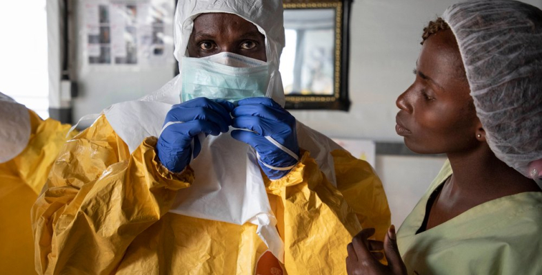 Mitarbeiter in Schutzausrüstung vor Ebola-Transitzentrum