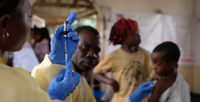 Mitarbeiterin befüllt Spritze mit Impfstoff