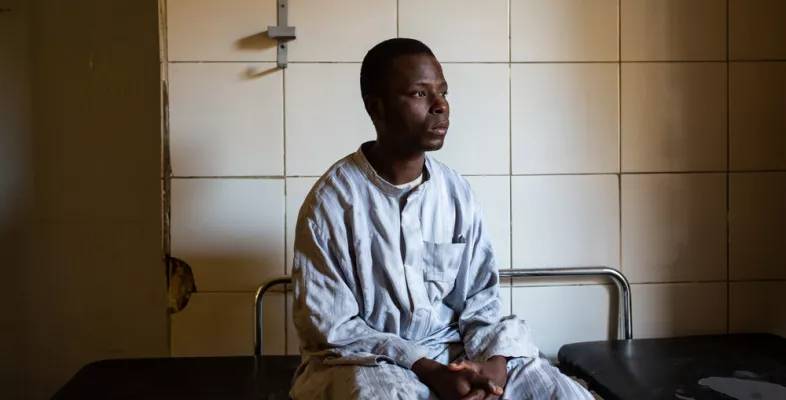 Ein Mann sitzt auf einer Trage