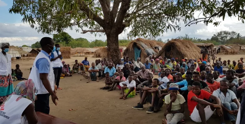 Unsere Mitarbeitenden sprechen mit Menschen in einem Vertriebenen-Camp.