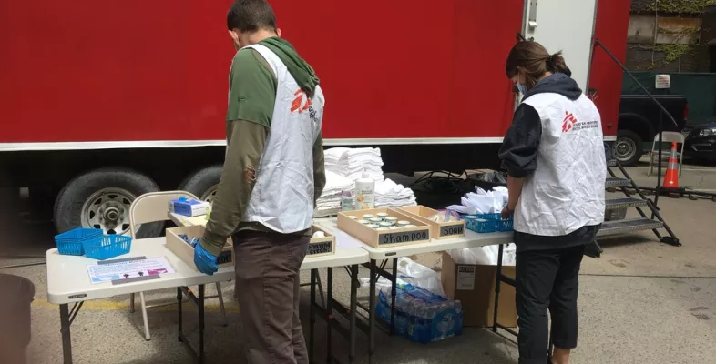 Mitarbeiter*innen stellen Hygieneprodukte vor öffentlichen Duschen bereit