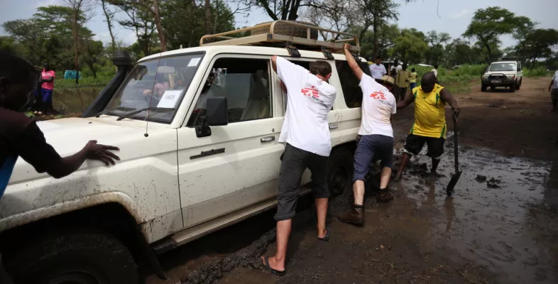 Geflüchtete Uganda Teamarbeit Geländewagen