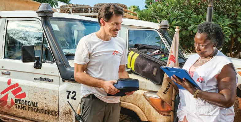 Zwei Mitarbeiter*innen kontollieren die Materialien für die mobile Klinik