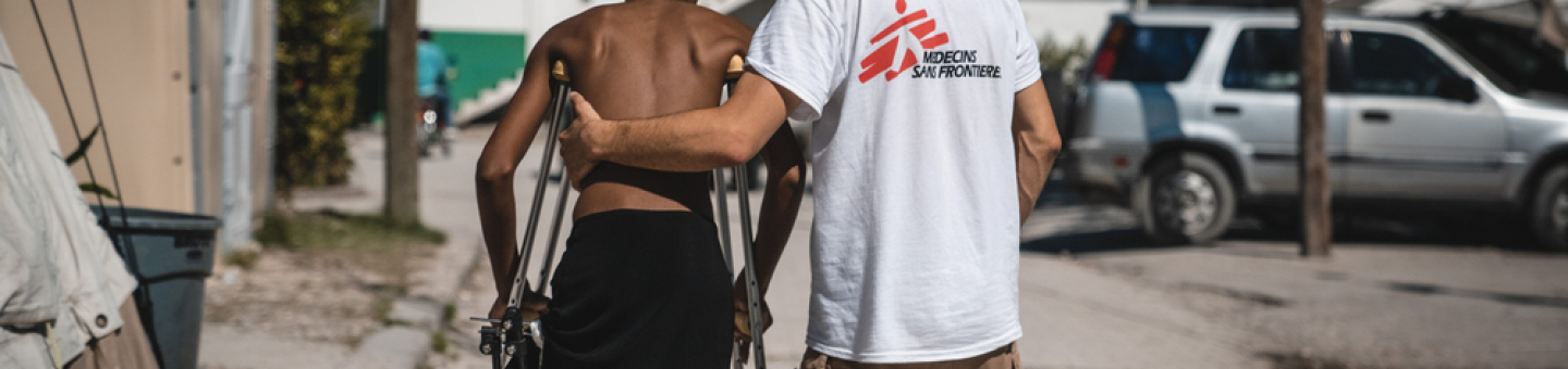 Mitarbeitende von Ärzte ohne Grenzen arbeiten bereits seit 30 Jahren in Haiti. Durch die akute Treibstoffkrise könnte ihre Arbeit eingeschränkt werden. Ein Mitarbeiter von Ärzte ohne Grenzen stützt einen Mann auf Krücken