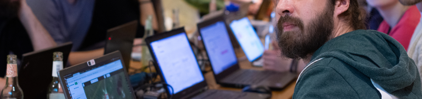 Menschen vor Computern sitzend schauen alle in eine Richtung.