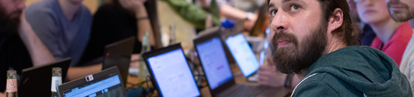 Menschen vor Computern sitzend schauen alle in eine Richtung.